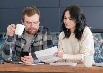 Photo by Mikhail Nilov from Pexels: https://www.pexels.com/photo/a-man-looking-at-the-paper-while-holding-a-coffee-and-phone-6963043/