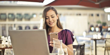 Photo by Andrea Piacquadio from Pexels: https://www.pexels.com/photo/woman-wearing-purple-shirt-holding-smartphone-white-sitting-on-chair-826349/