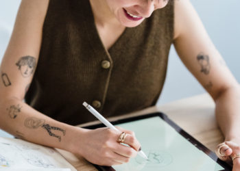 Photo by Michael Burrows from Pexels: https://www.pexels.com/photo/smiling-woman-drawing-on-graphic-tablet-with-pencil-at-table-7147701/