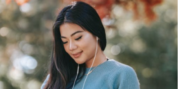 Image source: https://www.pexels.com/photo/young-cheerful-woman-listening-to-audio-book-using-smartphone-in-park-5965925/