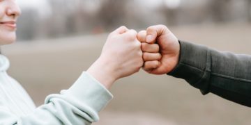 Photo by Andres  Ayrton: https://www.pexels.com/photo/man-and-happy-woman-greeting-each-other-with-fist-bump-6551298/