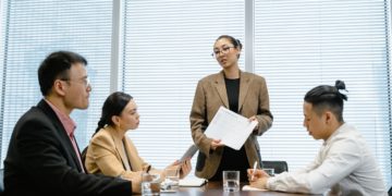 Photo by MART PRODUCTION: https://www.pexels.com/photo/woman-standing-up-in-front-of-colleagues-during-meeting-7644066/