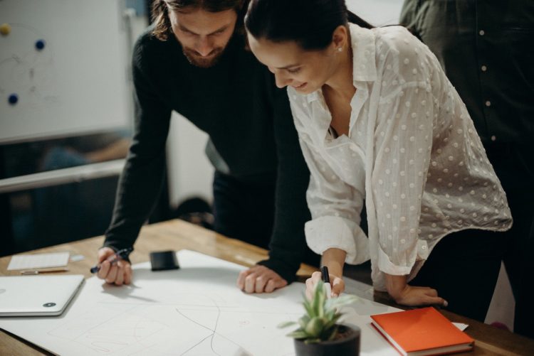 Photo by cottonbro studio: https://www.pexels.com/photo/man-and-woman-leaning-on-table-staring-at-white-board-on-top-of-table-having-a-meeting-3205570/