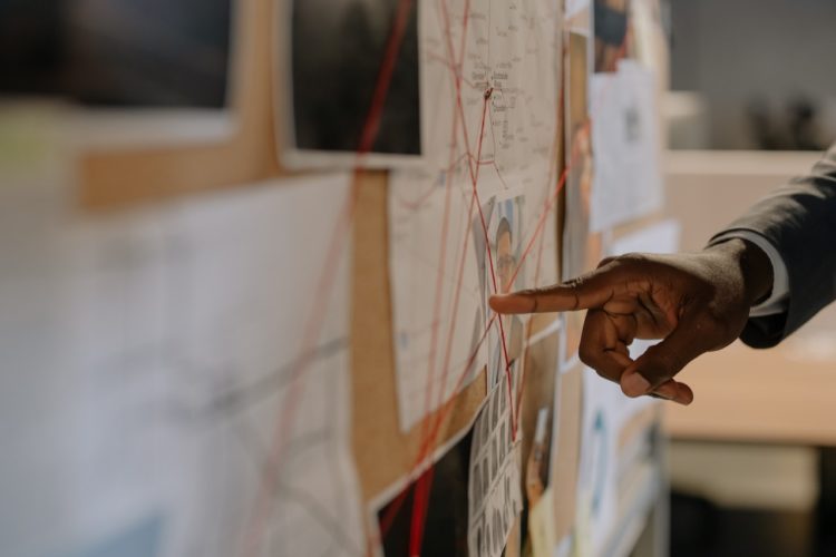 Photo by cottonbro studio: https://www.pexels.com/photo/close-up-shot-of-a-person-pointing-at-evidence-board-8369524/