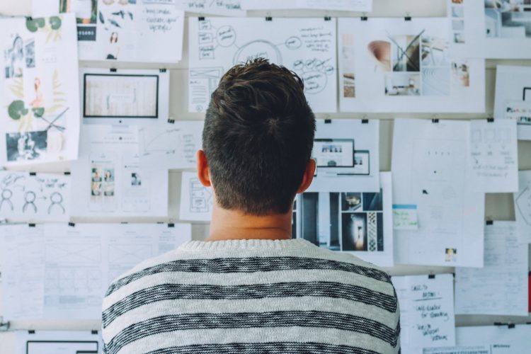 Photo by Startup Stock Photos from Pexels: https://www.pexels.com/photo/man-wearing-black-and-white-stripe-shirt-looking-at-white-printer-papers-on-the-wall-212286/