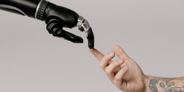 Photo by cottonbro studio: https://www.pexels.com/photo/bionic-hand-and-human-hand-finger-pointing-6153354/