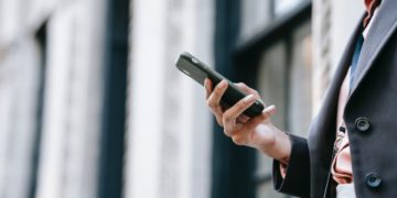 Photo by Ono Kosuki: https://www.pexels.com/photo/crop-businesswoman-messaging-on-smartphone-while-standing-near-building-on-street-5999786/
