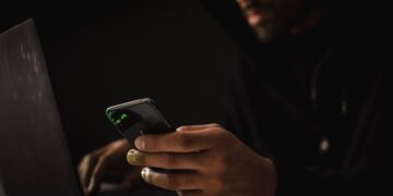 Photo by Sora Shimazaki: https://www.pexels.com/photo/crop-ethnic-hacker-with-smartphone-typing-on-laptop-in-dark-room-5935792/