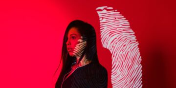 Photo by Cleyton Ewerton: https://www.pexels.com/photo/woman-with-fingerprint-reflection-on-red-background-5063551/