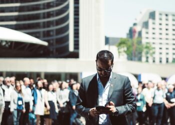Photo by Yama Saighani: https://www.pexels.com/photo/selective-focus-photography-of-man-holding-smartphone-while-standing-near-people-624367/