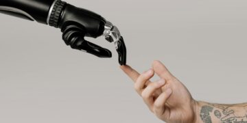 Photo by cottonbro studio: https://www.pexels.com/photo/bionic-hand-and-human-hand-finger-pointing-6153354/