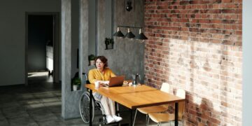 Photo by Marcus Aurelius: https://www.pexels.com/photo/a-woman-wearing-orange-long-sleeves-on-a-wheel-chair-beside-a-wooden-table-using-a-laptop-4064698/